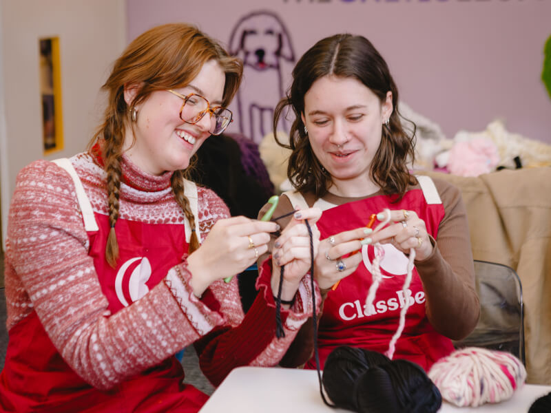 Two women enjoying a knitting class for a 30th birthday